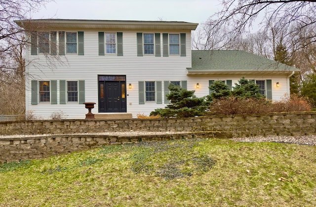 colonial inspired home with a front lawn