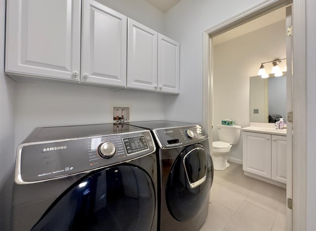 laundry room featuring washing machine and dryer, sink, and light tile patterned flooring