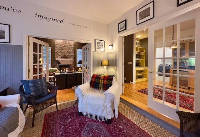 living area featuring french doors, beverage cooler, and wood-type flooring