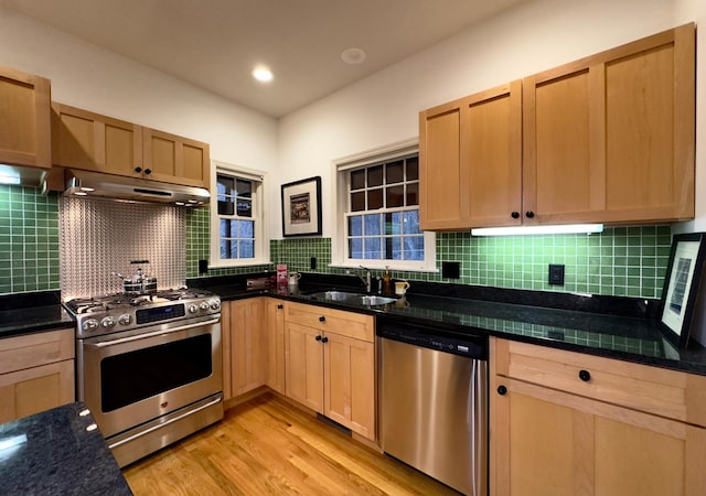 kitchen with light brown cabinetry, backsplash, stainless steel appliances, sink, and light hardwood / wood-style flooring