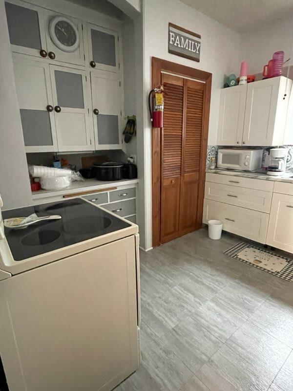 kitchen featuring white cabinets and white appliances