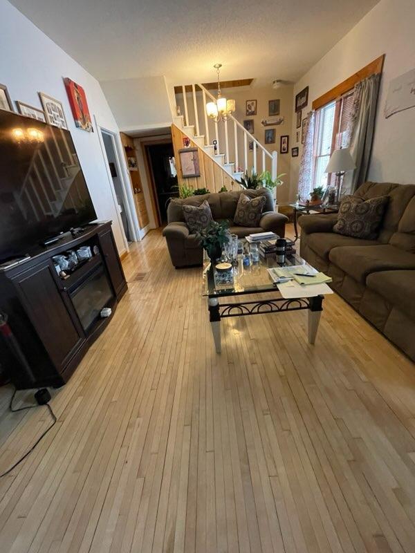 living room with a chandelier and light hardwood / wood-style floors