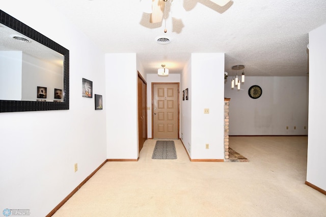 corridor with carpet flooring and a textured ceiling