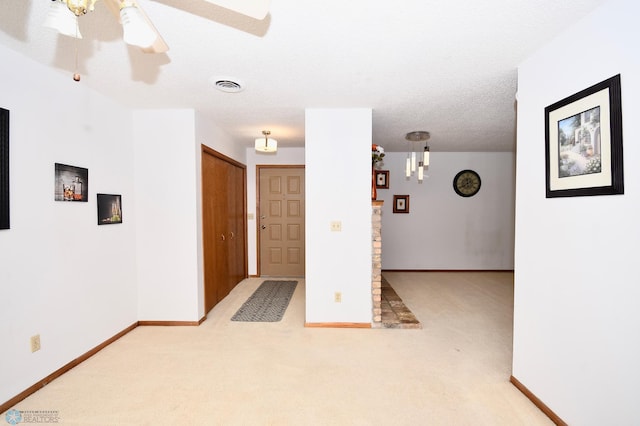 carpeted empty room featuring ceiling fan and a textured ceiling