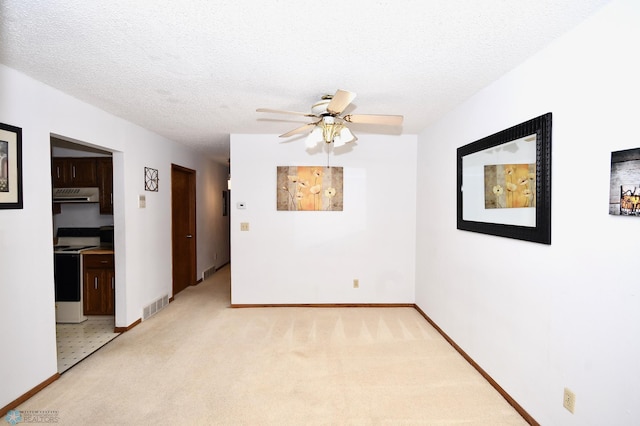 carpeted empty room with a textured ceiling and ceiling fan