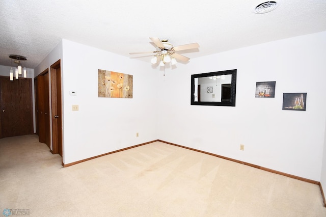 carpeted spare room featuring a textured ceiling and ceiling fan