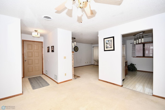 carpeted foyer entrance with a textured ceiling and ceiling fan