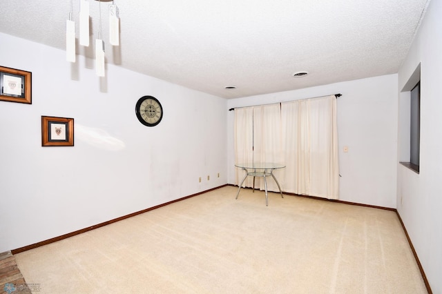 carpeted spare room featuring a textured ceiling