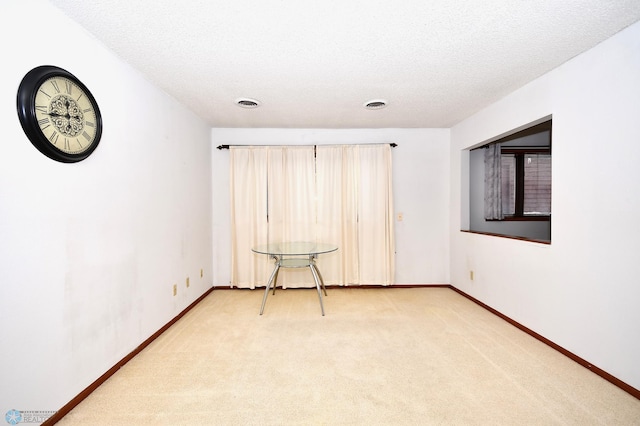 carpeted empty room with a textured ceiling