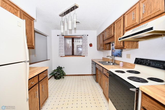 kitchen with a textured ceiling, white appliances, hanging light fixtures, and sink