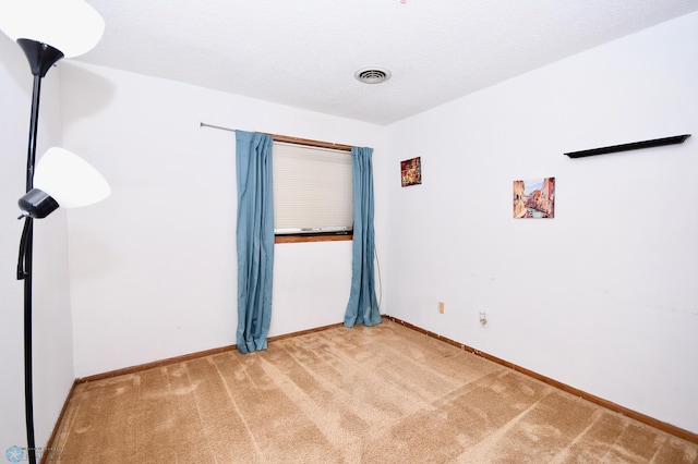 carpeted empty room with a textured ceiling