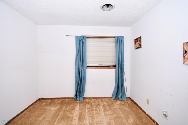 empty room featuring a textured ceiling and carpet floors