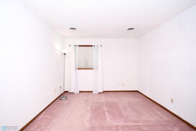 carpeted spare room with a textured ceiling