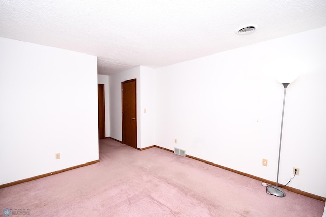 unfurnished room featuring light colored carpet and a textured ceiling