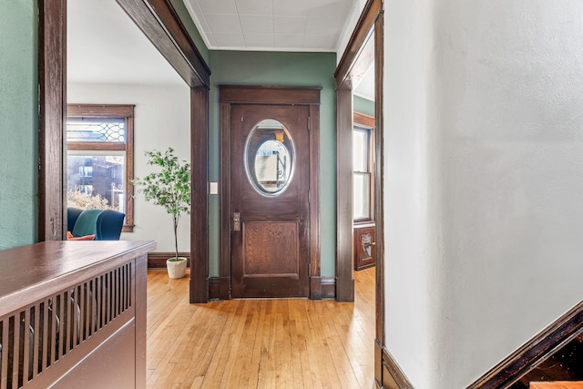 foyer entrance featuring light wood-type flooring and ornamental molding