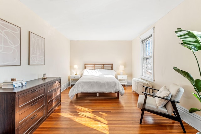 bedroom with light hardwood / wood-style flooring and radiator