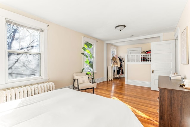 bedroom with radiator and hardwood / wood-style floors