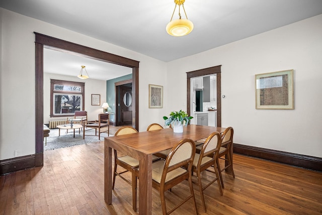 dining space with hardwood / wood-style flooring and baseboards