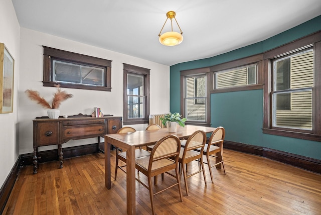 dining room with baseboards and hardwood / wood-style flooring