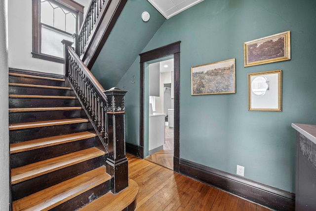 staircase featuring hardwood / wood-style flooring and baseboards