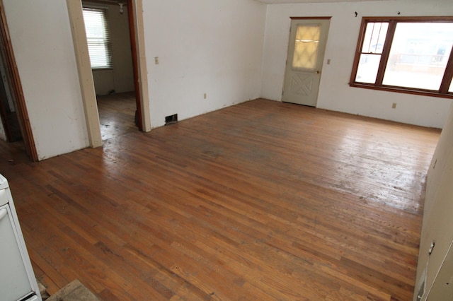 unfurnished room with a wealth of natural light and dark wood-type flooring