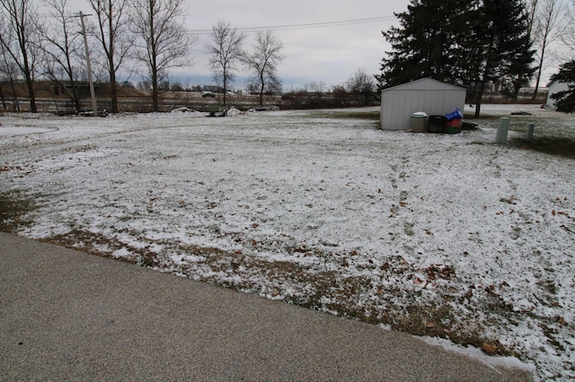 yard covered in snow featuring a storage unit