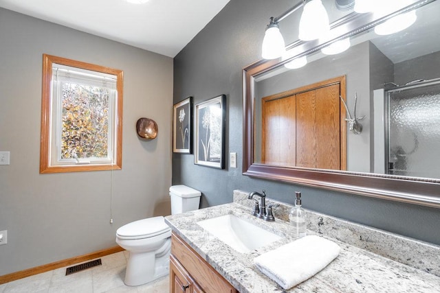 bathroom featuring tile patterned flooring, vanity, toilet, and an enclosed shower