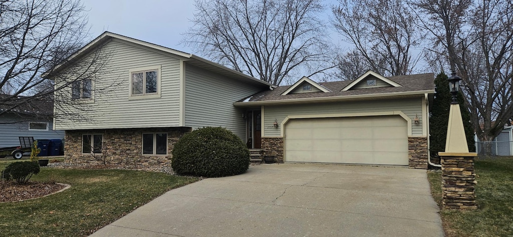 view of front of house with a garage and a front lawn