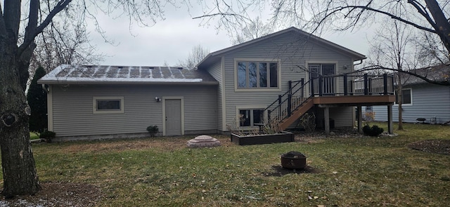 rear view of property with a yard, an outdoor fire pit, and a wooden deck