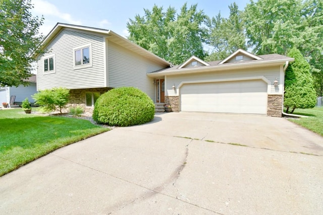 tri-level home featuring a garage and a front lawn