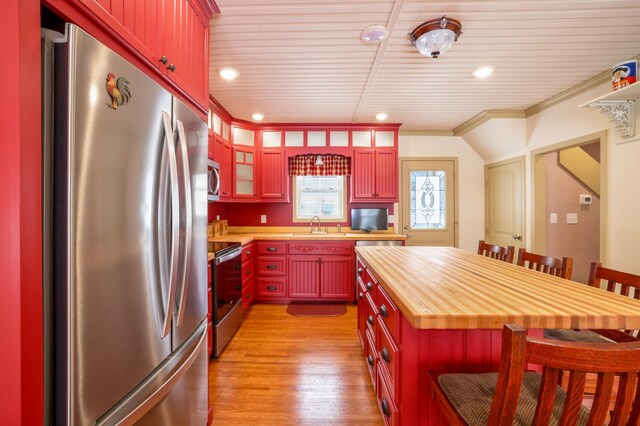 kitchen with wood counters, sink, crown molding, appliances with stainless steel finishes, and light hardwood / wood-style floors