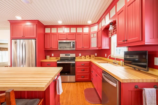 kitchen featuring sink, stainless steel appliances, butcher block countertops, and light hardwood / wood-style flooring