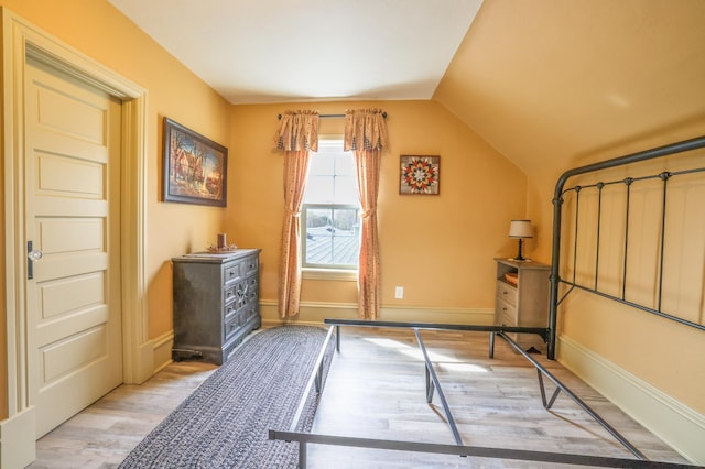 unfurnished bedroom with light hardwood / wood-style floors and lofted ceiling