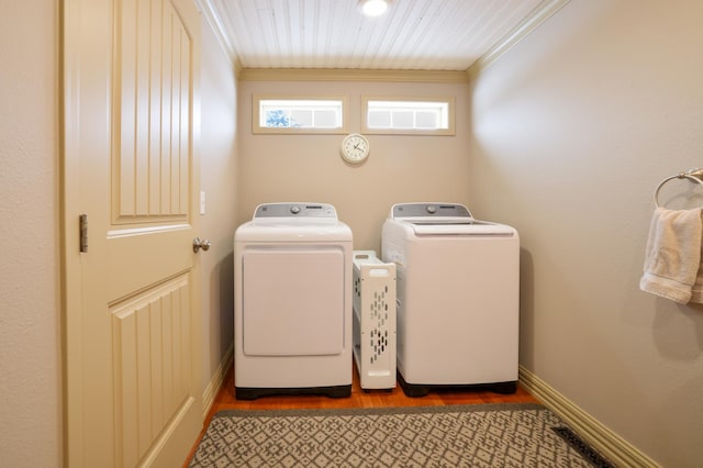 washroom with wooden ceiling, ornamental molding, and washing machine and clothes dryer