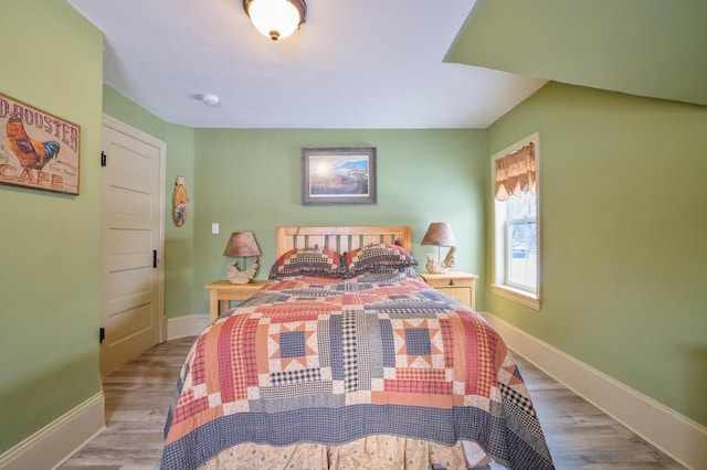 bedroom featuring baseboards and wood finished floors