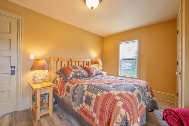 bedroom with baseboards and wood finished floors