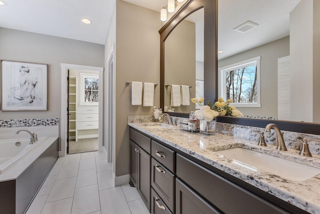 bathroom with tile patterned flooring, vanity, and a bathing tub