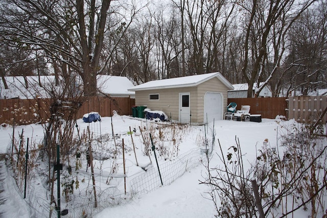 snowy yard with an outdoor structure and a garage