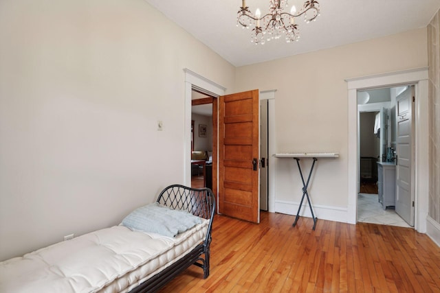 2724 Longfellow Ave, Minneapolis, MN 55407 - bedroom featuring light wood-type flooring, a chandelier, and baseboards