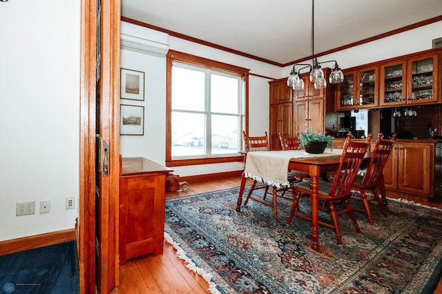 dining room featuring light hardwood / wood-style floors, a wall unit AC, and ornamental molding