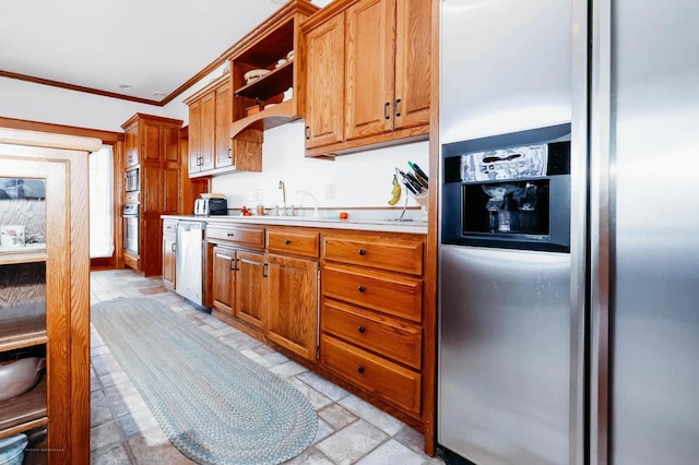 kitchen with sink, ornamental molding, and stainless steel appliances