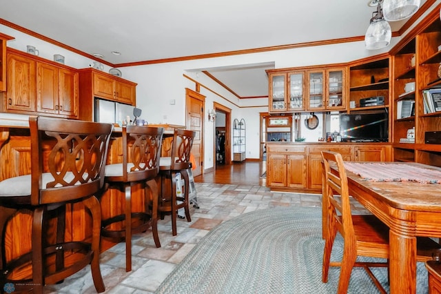 kitchen with decorative light fixtures, white refrigerator, and ornamental molding