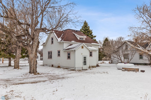 view of snow covered back of property