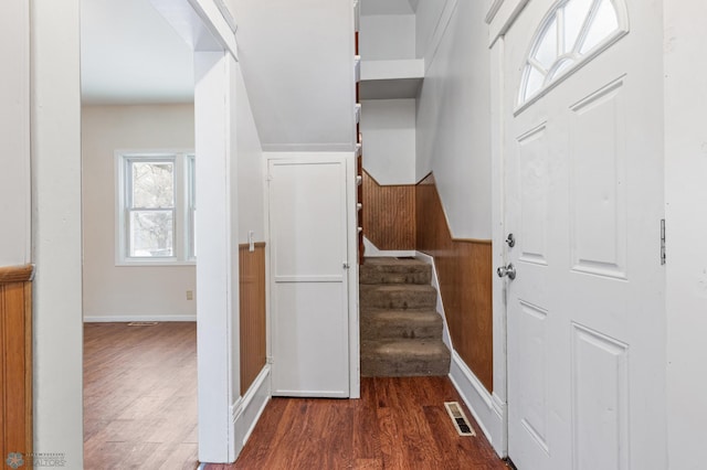 stairs with hardwood / wood-style floors and wooden walls