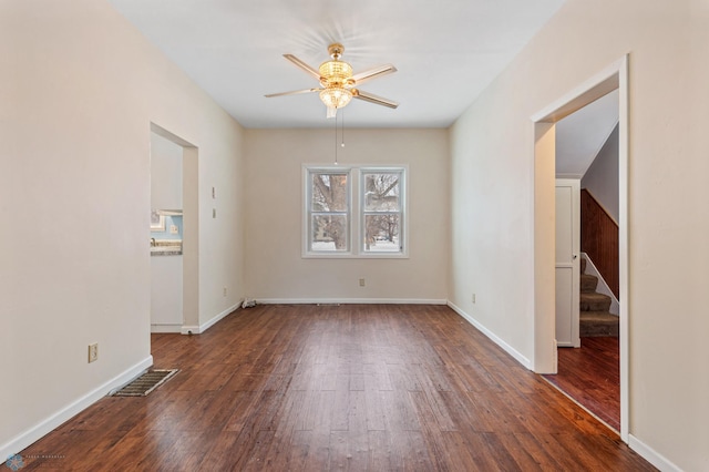 empty room with ceiling fan and dark wood-type flooring