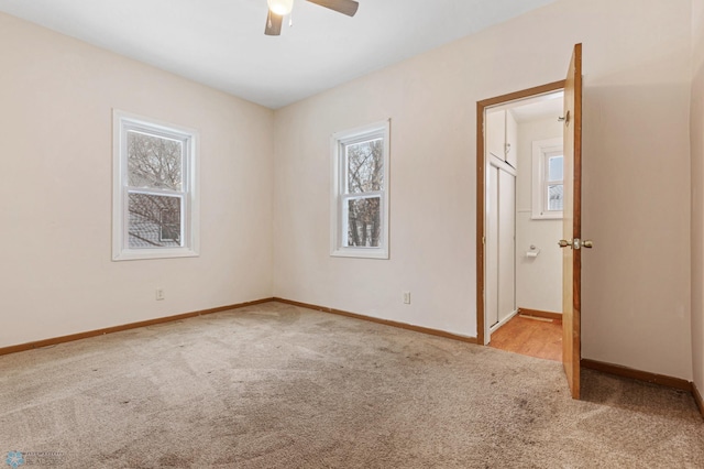 spare room with ceiling fan and light colored carpet