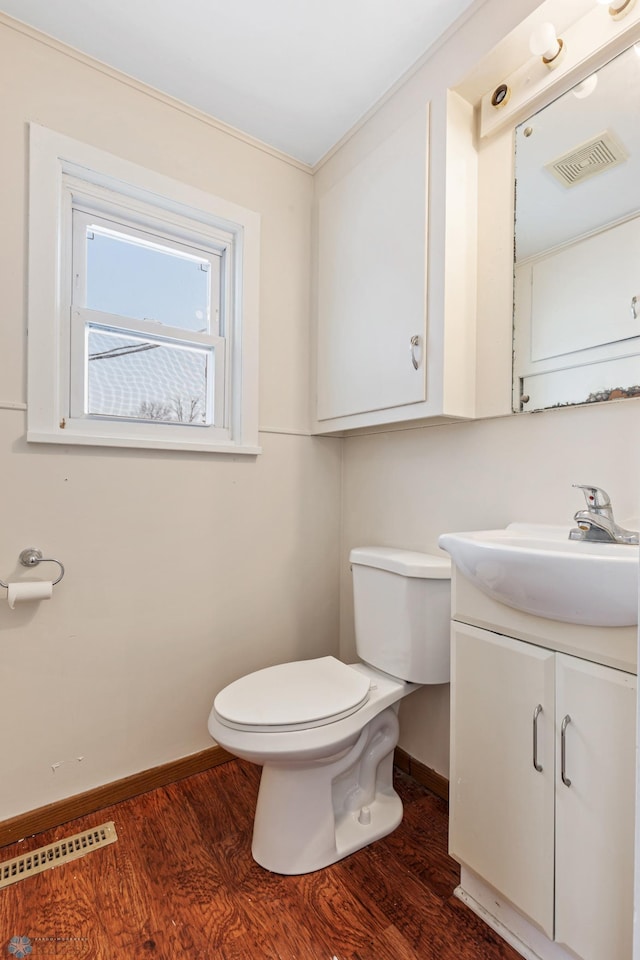 bathroom with wood-type flooring, vanity, toilet, and ornamental molding