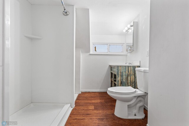 bathroom featuring a shower, hardwood / wood-style flooring, and toilet