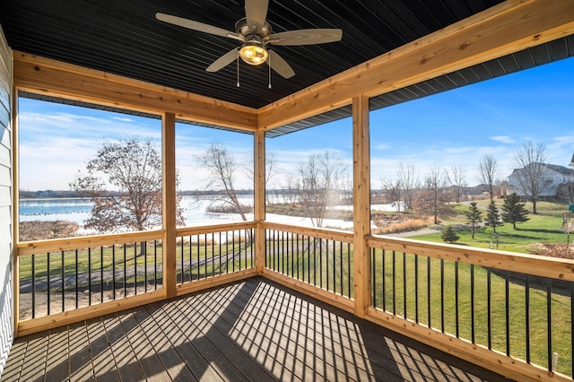 sunroom featuring ceiling fan, a water view, and wooden ceiling