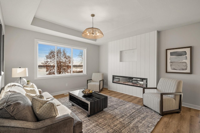 living room with a fireplace, hardwood / wood-style floors, and a notable chandelier